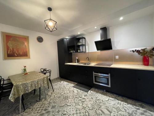 a kitchen with a table and a sink and a counter at APARTAMENT KRÓLEWSKI CENTRUM NIEPOŁOMICE in Niepołomice
