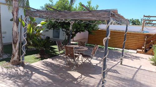 a patio with a table and chairs under a pergola at Villa Turicchio in Taranto