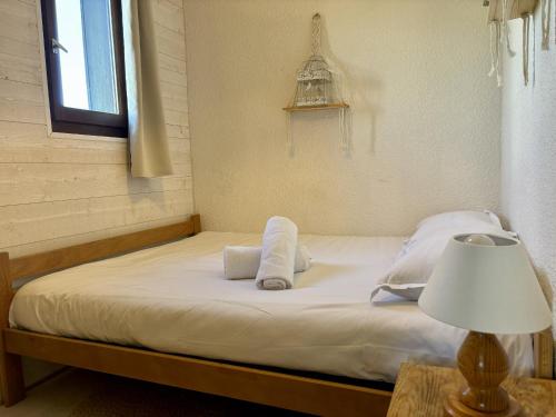 - un lit avec des draps et des oreillers blancs à côté d'une fenêtre dans l'établissement Mont Lachat - Central - Vues magnifiques, à Saint-Gervais-les-Bains