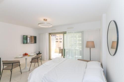 - une chambre blanche avec un lit blanc et une table dans l'établissement Studio in Les Résidences du Palais, à Nice