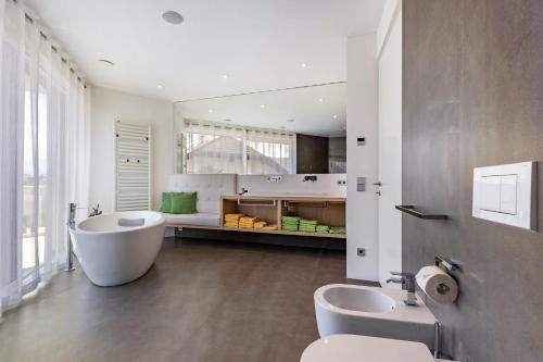 een badkamer met een bad, een toilet en een wastafel bij Villa Aich in San Paolo