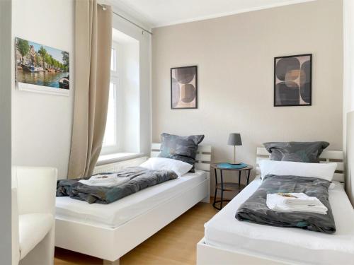 een slaapkamer met 2 bedden en een raam bij Gemütliches Apartment, Seenähe, WM, WLAN, Balkon in Markkleeberg
