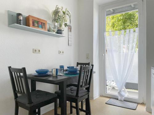 a dining room with a table and chairs and a window at Gemütliches Apartment, Seenähe, WM, WLAN, Balkon in Markkleeberg