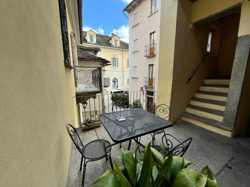 een patio met een tafel en stoelen op een balkon bij Agriturismo Edoardo Patrone in Domodossola