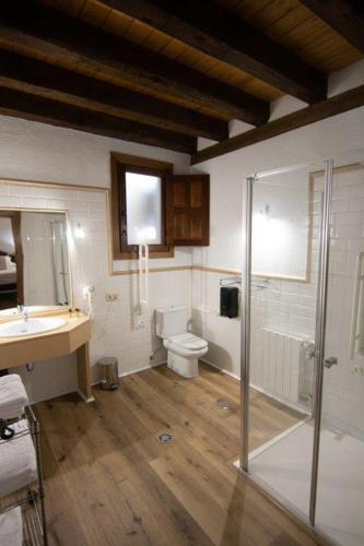 a bathroom with a shower and a toilet and a sink at Hospedium Hotel Rural Abadía de Yuste in Cuacos de Yuste