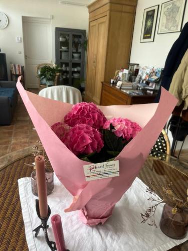 a bouquet of pink flowers sitting on a table at Le prieuré de Saint Thibault in Saint-Thibault-des-Vignes