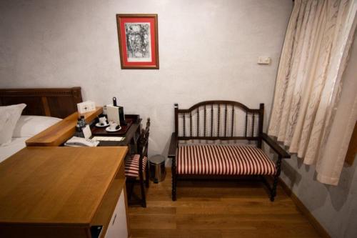 a bedroom with a desk and a bed and a chair at Hospedium Hotel Rural Abadía de Yuste in Cuacos de Yuste