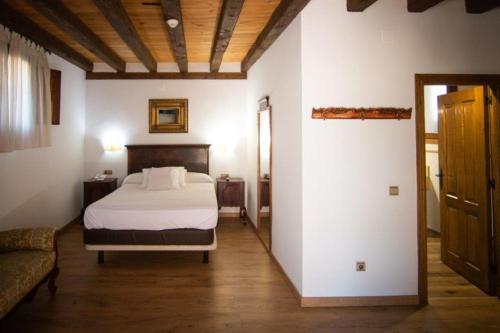 a bedroom with a bed and a couch at Hospedium Hotel Rural Abadía de Yuste in Cuacos de Yuste