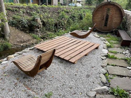 zwei Holzbänke und ein Holztisch im Garten in der Unterkunft Chalupa Černý Důl in Lauterwasser