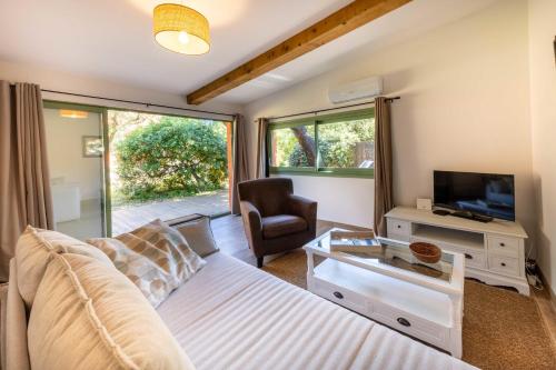 a living room with a bed and a tv and a couch at 06BV2 Nice cottage with pool in Grasse