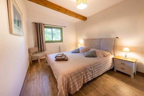 une chambre avec un lit, une chaise et une fenêtre dans l'établissement 06BV2 Nice cottage with pool, à Grasse