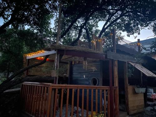a tree house with a porch and a deck at Appartement dans une maison de pays in Briançon