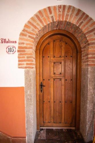 a wooden door in a brick arch way at Hospedium Hotel Rural Abadía de Yuste in Cuacos de Yuste
