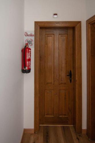 a wooden door in a room with a fire hydrant on the wall at Hospedium Hotel Rural Abadía de Yuste in Cuacos de Yuste