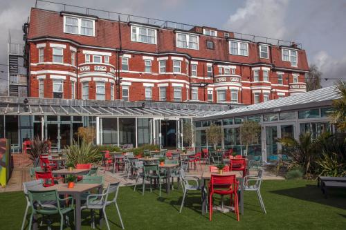 a building with tables and chairs in front of a building at Bournemouth West Cliff Hotel & Spa in Bournemouth