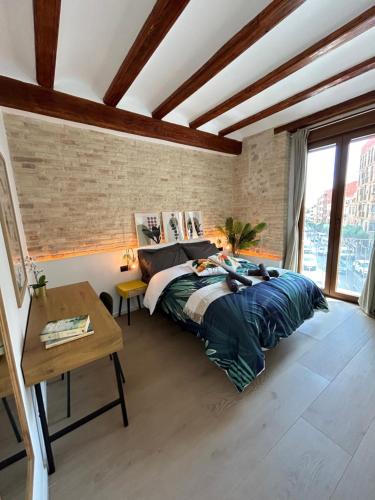 1 dormitorio con 1 cama grande y 1 mesa en Apartments & Boutique Meraki, en Ontinyent