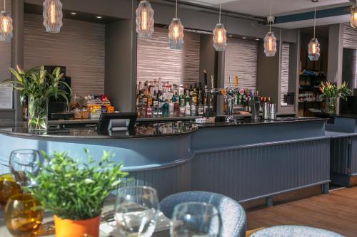 ボーンマスにあるBournemouth West Cliff Hotel & Spaのテーブルと椅子のあるレストラン内のバー