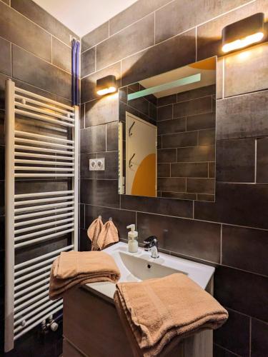 une salle de bain avec un lavabo et un miroir dans l'établissement Color Addict, à Saint-Étienne