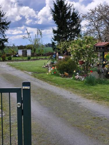 a gravel road with a gate in a yard at Am Storchennest in Ahrenshagen