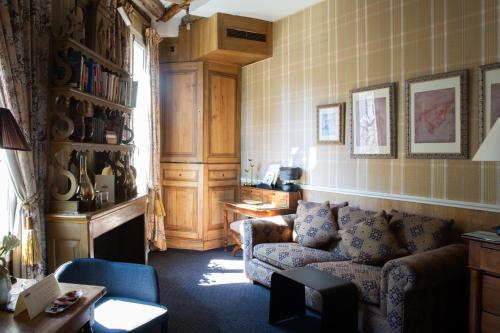 a living room with a couch and a table at Hôtel Le Relais Saint-Germain in Paris