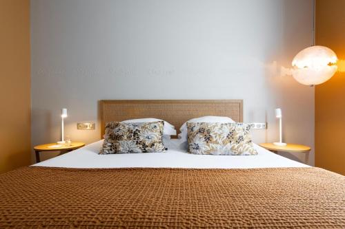 a bedroom with a large bed with two pillows at Hôtel Boutique Cézanne centre Aix-en-Provence in Aix-en-Provence