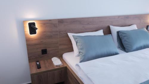 a bed with blue and white pillows in a room at Belvedere rooms A&E in Velika Kladuša