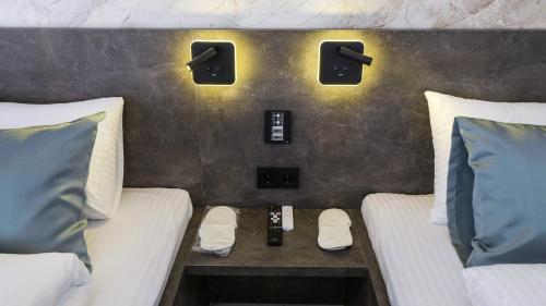 a room with two beds and a table between them at Belvedere rooms A&E in Velika Kladuša