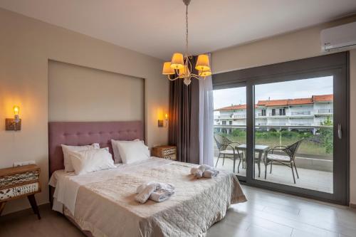 a bedroom with a large bed and a balcony at Villa Selena seafront in Hanioti