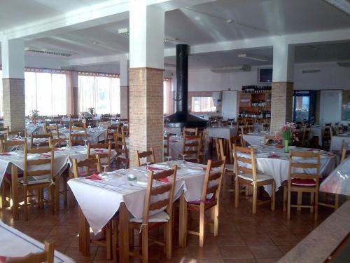 a dining room with white tables and chairs at Nefama Pensao in Ourique