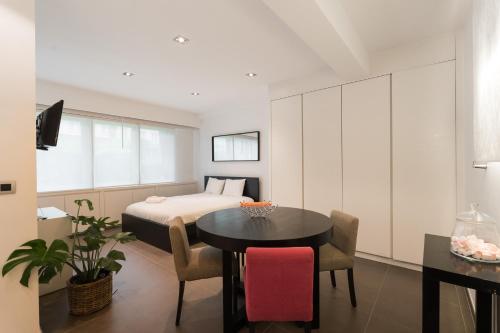 Cette chambre comprend un lit, une table et des chaises. dans l'établissement The Loft, à Bruxelles