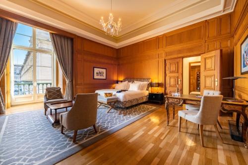 a bedroom with a bed and a table and chairs at Pousada de Lisboa - Small Luxury Hotels Of The World in Lisbon