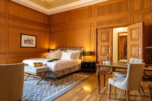 a bedroom with a bed and a table and chairs at Pousada de Lisboa - Small Luxury Hotels Of The World in Lisbon