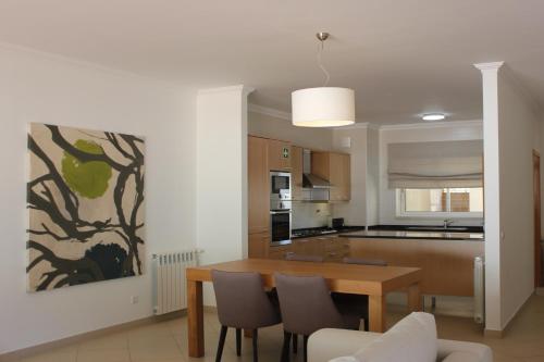 a kitchen and dining room with a table and chairs at Confortavel T2 in Óbidos