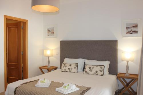 um quarto com uma cama com duas toalhas em Confortavel T2 em Óbidos