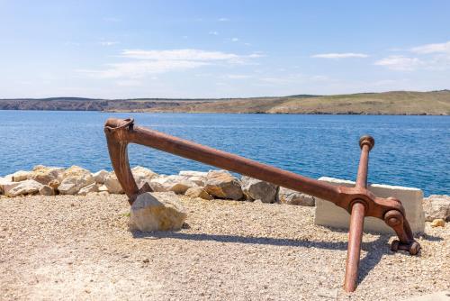 a metal object sitting on the shore of a body of water at Seaside Guesthouse by JR City Apartments in Jadranovo