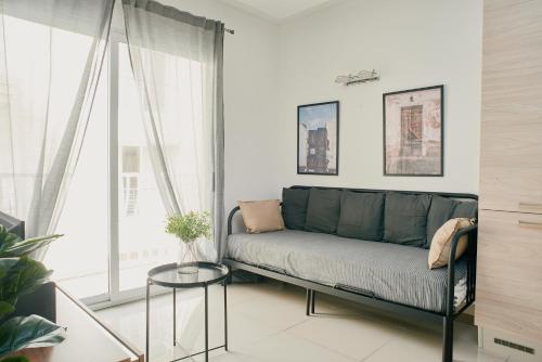 um sofá numa sala de estar com uma janela em Central & 1 min walk to the sea! "The Gallery" Apartment, Sliema em Sliema