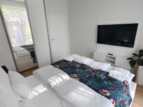 a living room with a white couch and a tv at Apartmán Verdi in Turčianske Teplice