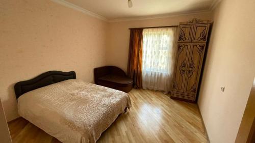 a bedroom with a bed and a window and a chair at Green Paradise in Ijevan