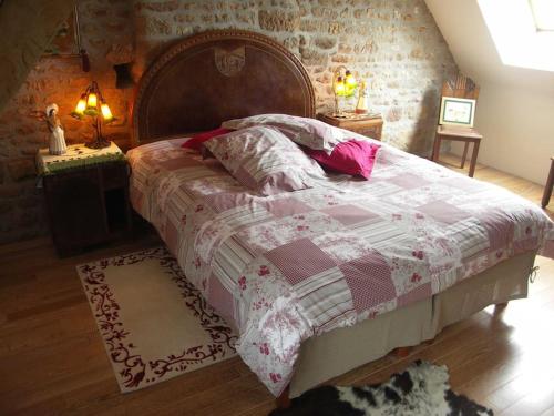 a bedroom with a large bed and two night stands at Gîte : La Cochetière : ancienne ferme 18éme in Le Grais