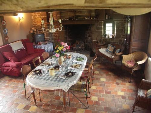 a living room with a table and a couch at Gîte : La Cochetière : ancienne ferme 18éme in Le Grais