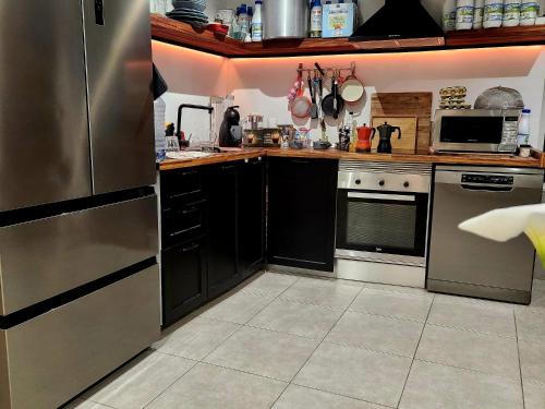 una cocina con electrodomésticos de acero inoxidable y armarios negros en Casa Salvia Bed and Breakfast, en Icod de los Vinos