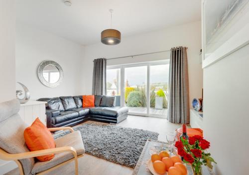 ein Wohnzimmer mit einem Sofa und einem Tisch in der Unterkunft SeaBreeze Holiday Apartment in Swanage