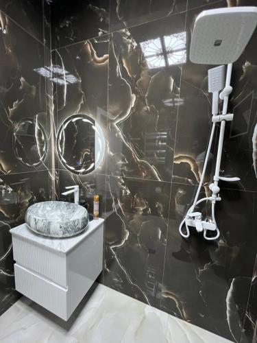 a bathroom with a black tiled wall at Qafqaz Modern Luxryland in Gabala