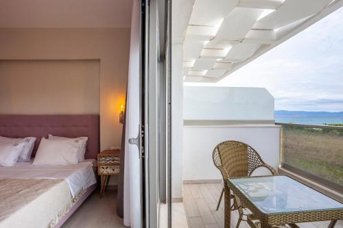 a bedroom with a bed and a glass table at Villa Selena seafront in Hanioti