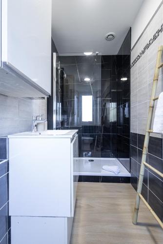 une salle de bain avec un lavabo et une baignoire dans l'établissement Cocon côtier, échappée mer, à 500m de la plage, à Villeneuve-Loubet