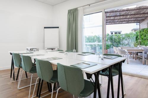 a conference room with a long table and green chairs at Hôtel Boutique Cézanne centre Aix-en-Provence in Aix-en-Provence