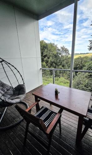 a porch with a hammock and a table and a swing at Byron Bay Hinterlands Dreaming Woods Cabin One in Bangalow