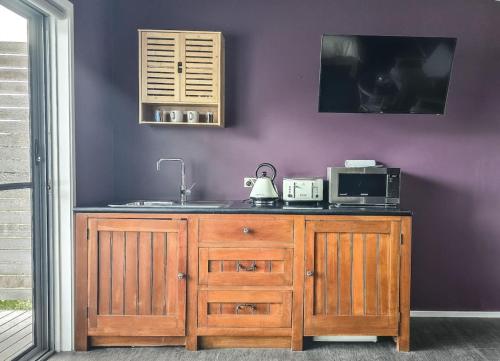 a kitchen with a counter with a sink and a microwave at Byron Bay Hinterlands Dreaming Woods Cabin One in Bangalow