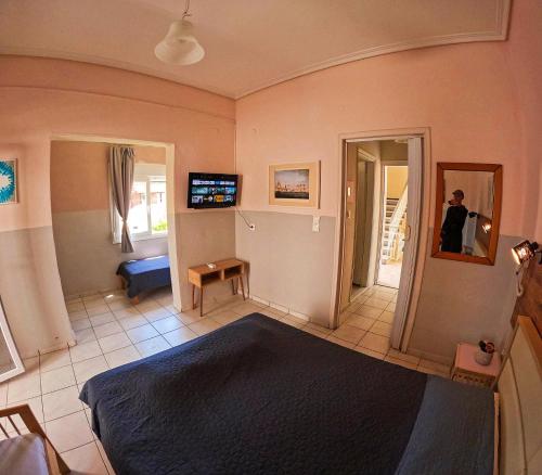a room with a bed and a person in a mirror at Garden House Katerina in Leptokaria