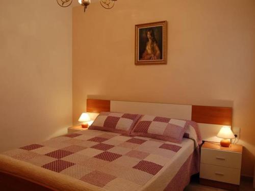a bedroom with a bed with two lamps and a picture on the wall at Camins 2 in Riumar
